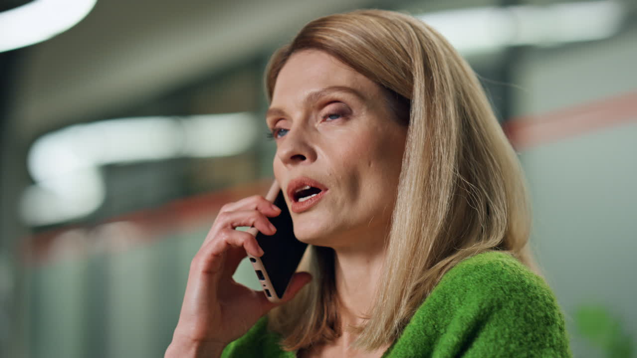 Serious businesswoman talking cellphone indoors portrait. Close up ceo calling