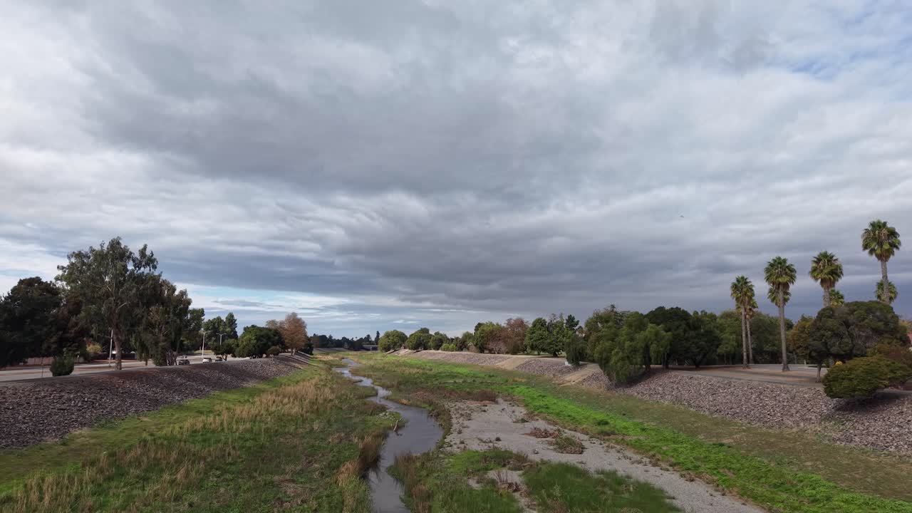Elevated footage captures the trail’s corridor weaving through tidy communities, highlighting the contrast between cultivated yards, open fields, and the steady rhythm of the creek’s movement