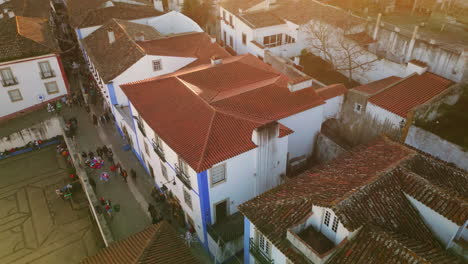 aerial picturesque town roofs at evening. busy street with walking people.