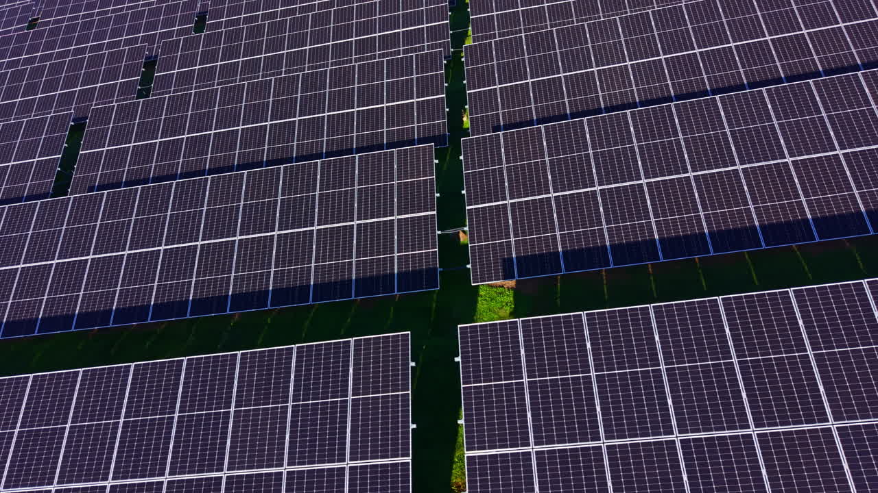 Vaste file di pannelli solari catturano la luce del sole in un ampio campo a mezzogiorno, mostrando la tecnologia dell'energia rinnovabile e un futuro sostenibile