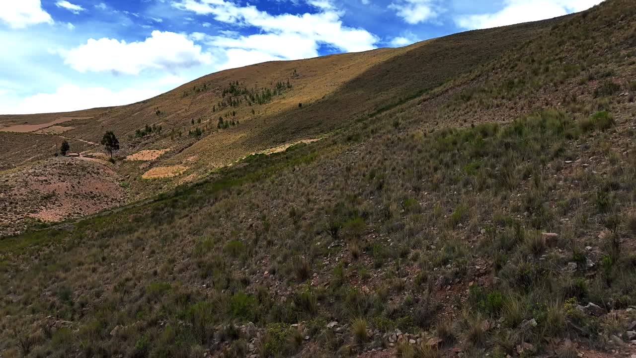 un avión no tripulado sube a una montaña boliviana, revelando los majestuosos andes a gran altitud