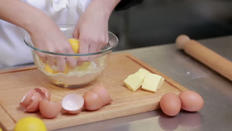 cocinero de pie en un mostrador y preparando la masa