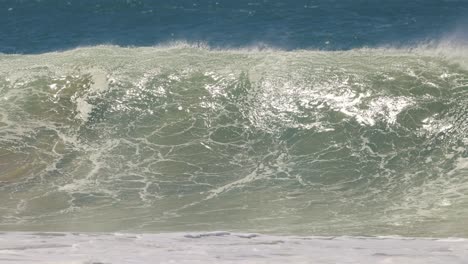 large ocean wave forming and crashing into white foam spray