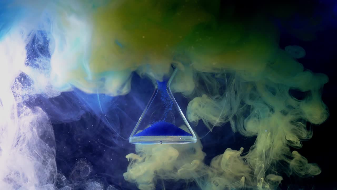 la silueta de arena que cae en un reloj de arena con un fondo borroso de burbujas coloridas