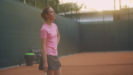 concentration before the last decisive serve. a woman on a tennis court in slow motion and sunlight