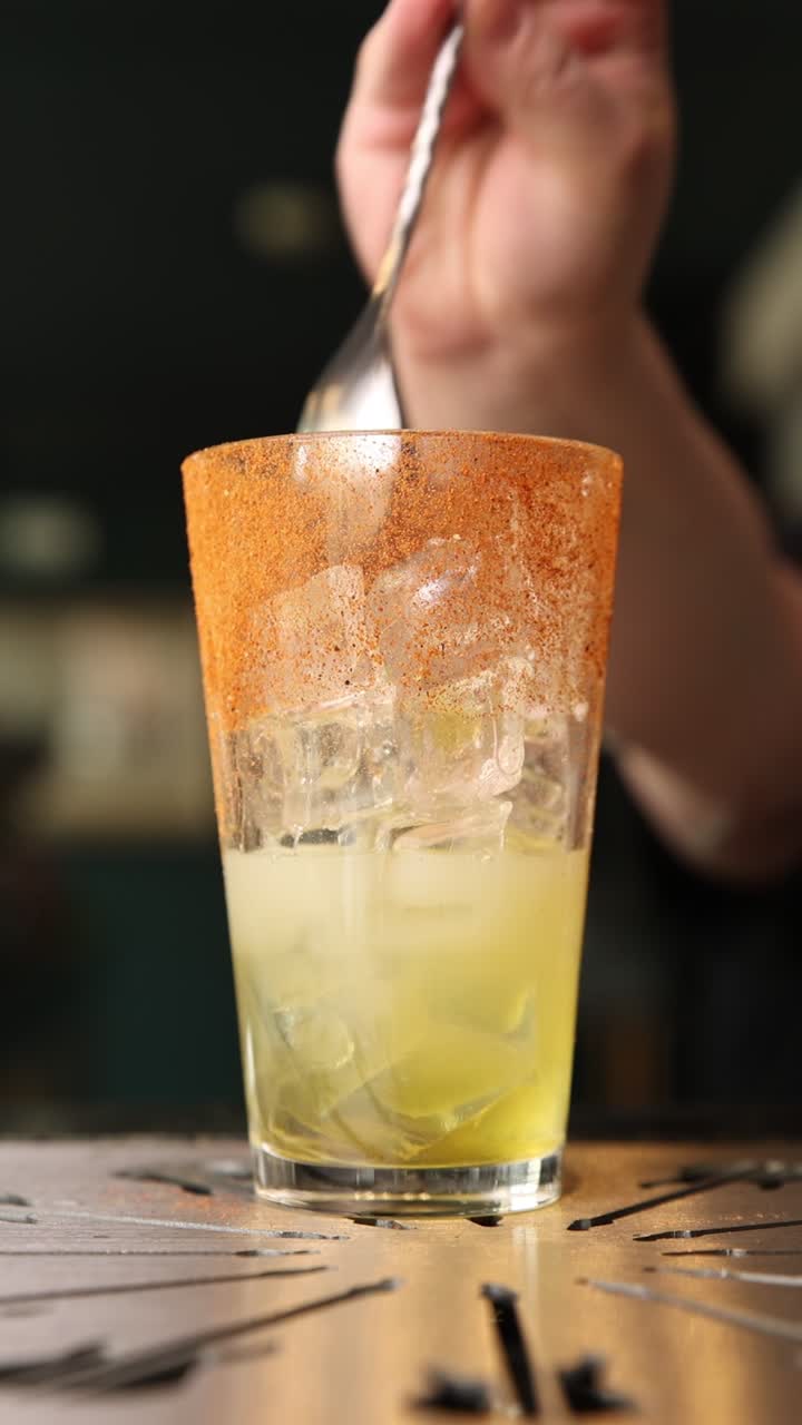 Barman prepara un cocktail con bordo speziato e guarnizione di ananas