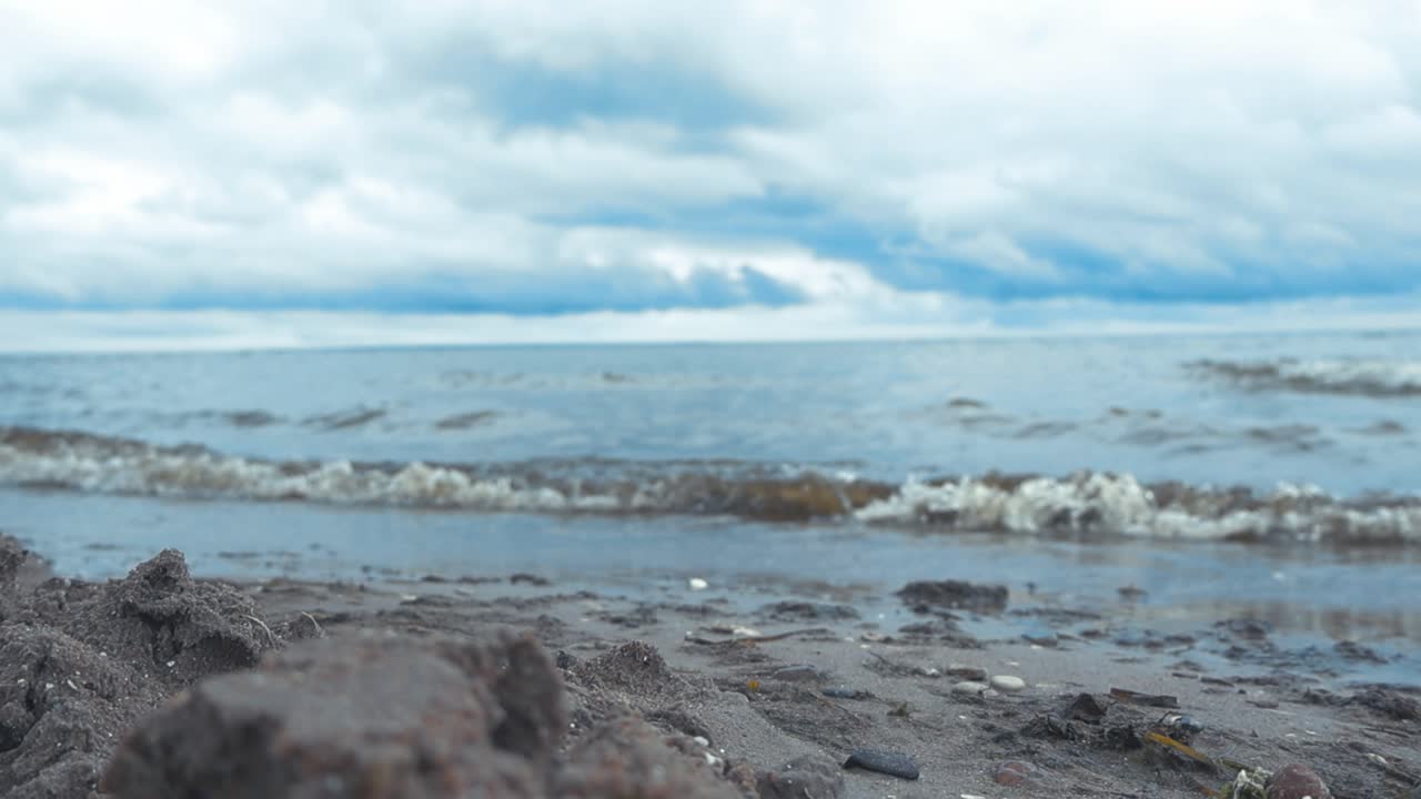 발트해 바다의 물결이 사레마 마인달라의 해변에 도착하는 근접 영상.