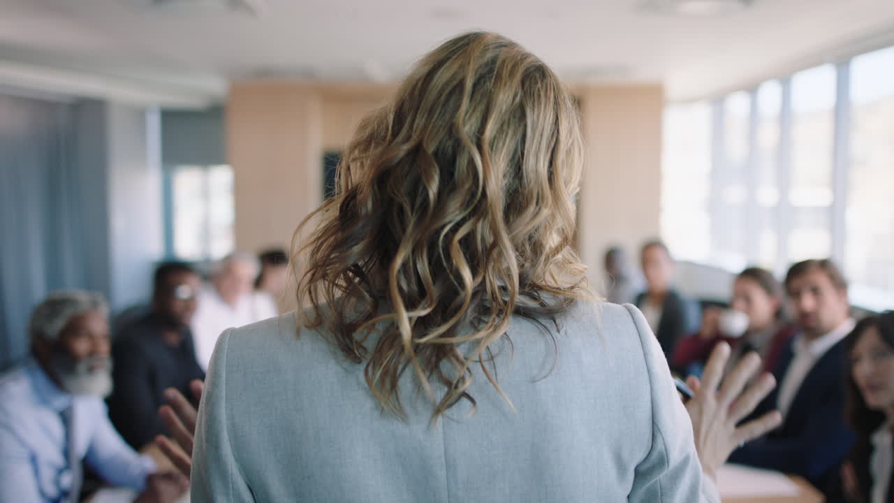 vista posteriore donna d'affari capogruppo che discute del progetto con i colleghi condivide idee creative in ufficio strategia di pianificazione della riunione 4k