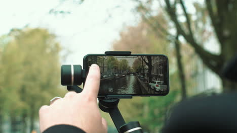 a man that starts to film the amsterdam canals on his phone with a gimbal