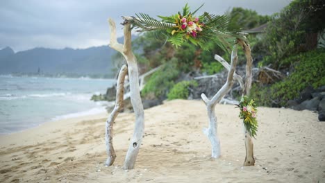 Toma-Panorámica-Suave-Y-En-Cámara-Lenta-De-Un-Hermoso-Arco-De-Compromiso-Que-Se-Encuentra-En-Una-Playa-Hawaiana-De-Arena