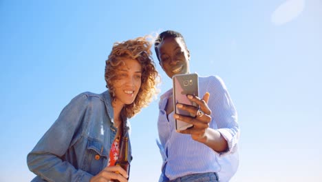 female friends taking selfie with mobile phone 4k