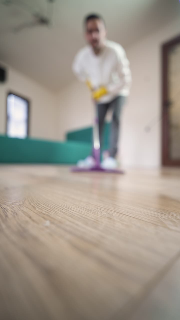 POV lifestyle scene of a man cleaning the floor with a mop, representing hygiene, routine, and healthy living at home