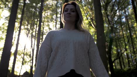 beautiful female model walks in forest wearing knitted jumper