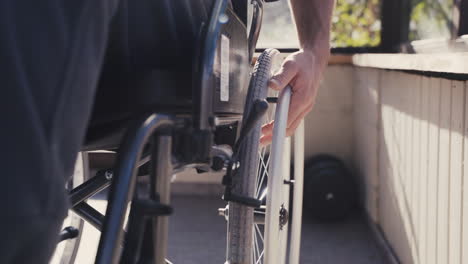 close up of male hand on wheel of wheelchair