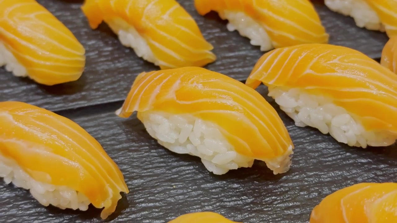Primo piano di sushi fresco al salmone elegantemente disposto su un piatto tradizionale. Presentazione di frutti di mare premium che evidenzia l'autentica cucina giapponese e la cultura culinaria gourmet.