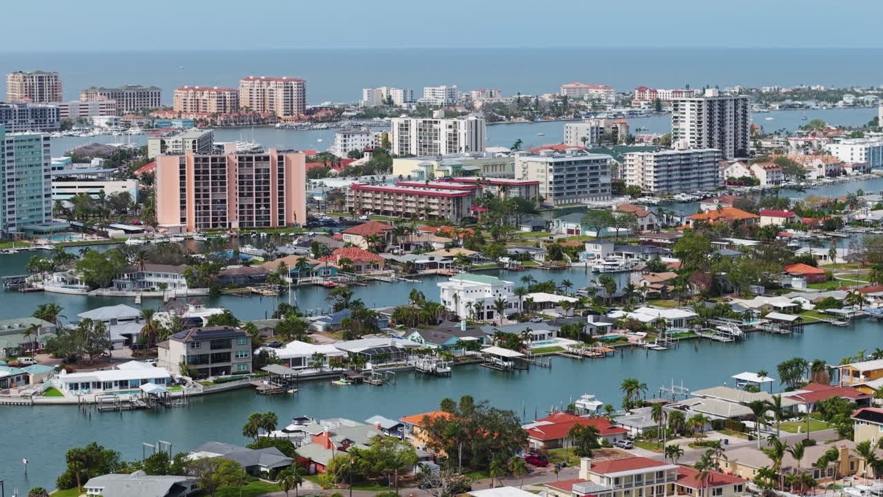 Telephoto drone shot tilting toward expensive homes in Island Estates, Florida