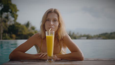 woman enjoying a smoothie by the pool