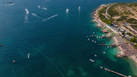 speedboats create trails across the turquoise waters of ksamil during a bright summer day