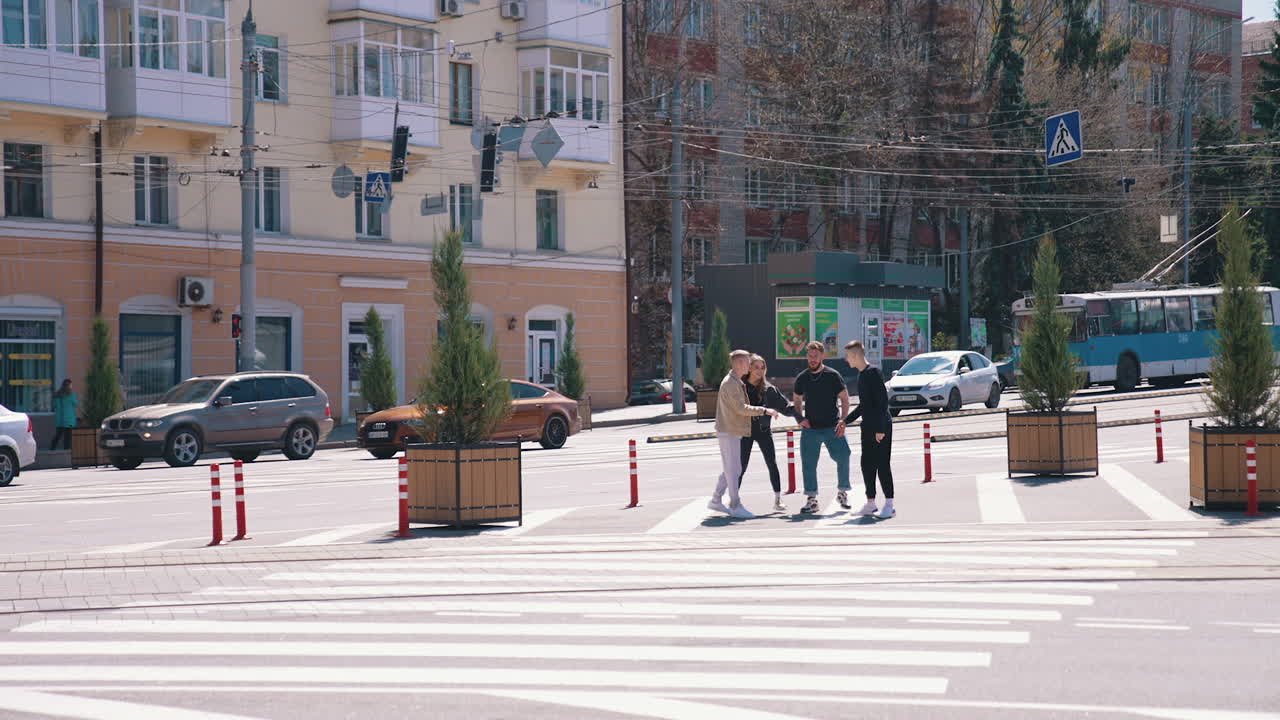 Young people in the city. Friends having fun together on urban background. Happy teenagers jumping at the same time near the road. Youth lifestyle.