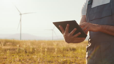 farmer using tablet at wind farm