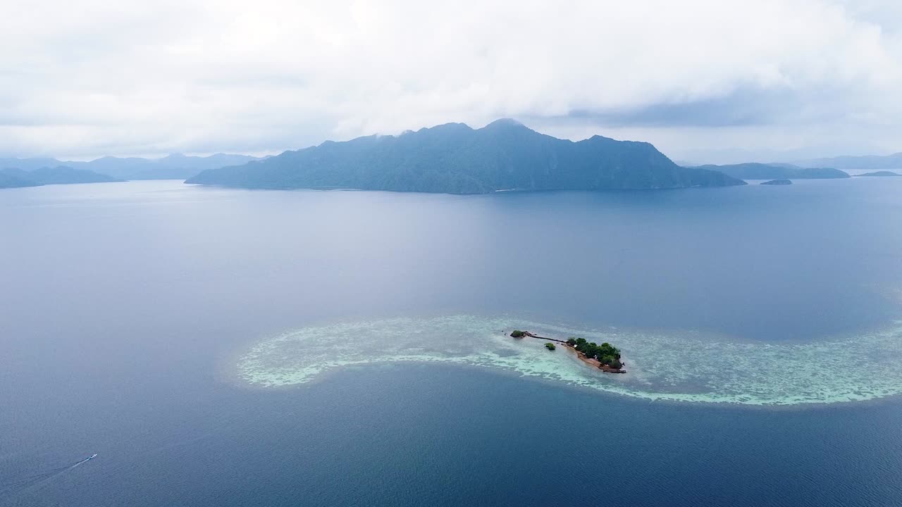 필리핀 팔라완의 코론 만에서 제2차 세계 대전의 선박 잔해, 원시 산호초 및 바다 전망으로 둘러싸인 산탄 섬 위로 떠오르는 공중 드론