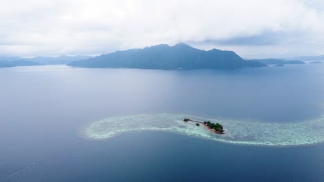 Drone-Aéreo-Elevándose-Sobre-La-Isla-Sangat-Rodeado-De-Naufragios-De-La-Segunda-Guerra-Mundial,-Prístinos-Arrecifes-De-Coral-Y-Vistas-Al-Océano-En-La-Bahía-De-Coron,-Palawan,-Filipinas