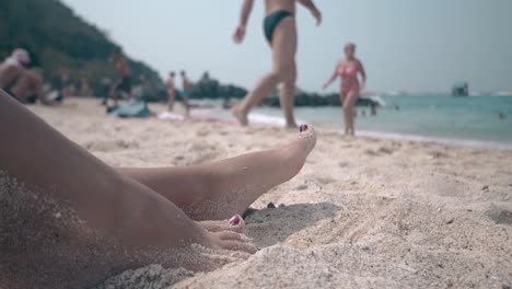 Schlankes-Mädchen-Mit-Roter-Pediküre-Vergräbt-Beine-Im-Warmen-Sand