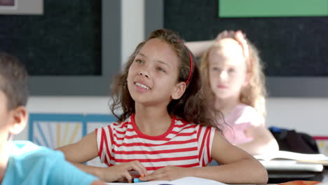 animation of school items icons over diverse schoolchildren raising hands