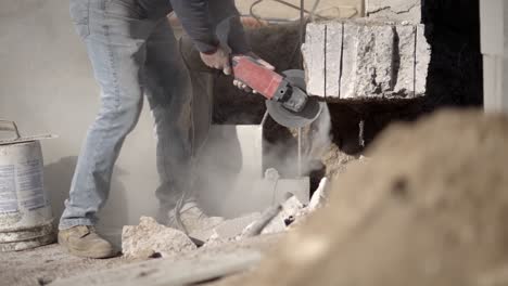 construction laborer using angle grinder to cut cement, concrete, low angle view