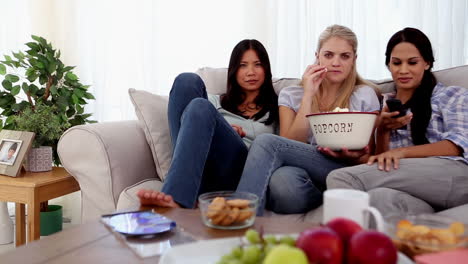 friends eating popcorn while watching a movie