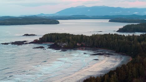 drone shot of tofino on vancouver island displaying autumn colors, rugged coastline, and ocean waves in a scenic aerial view.