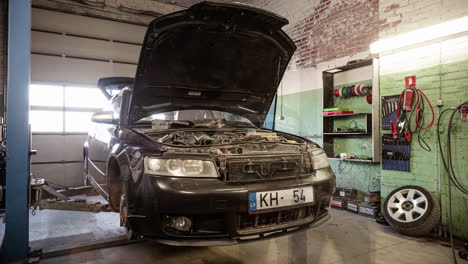 auto mechanic at work repairing car on a car lift alone in automotive service garage