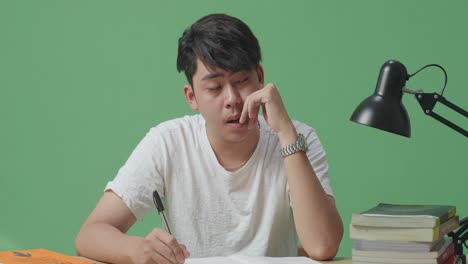 지친 학생이 공부하고 있습니다.
