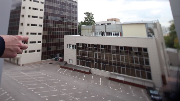Pessoa Usando Smartphone em um Estacionamento da Cidade