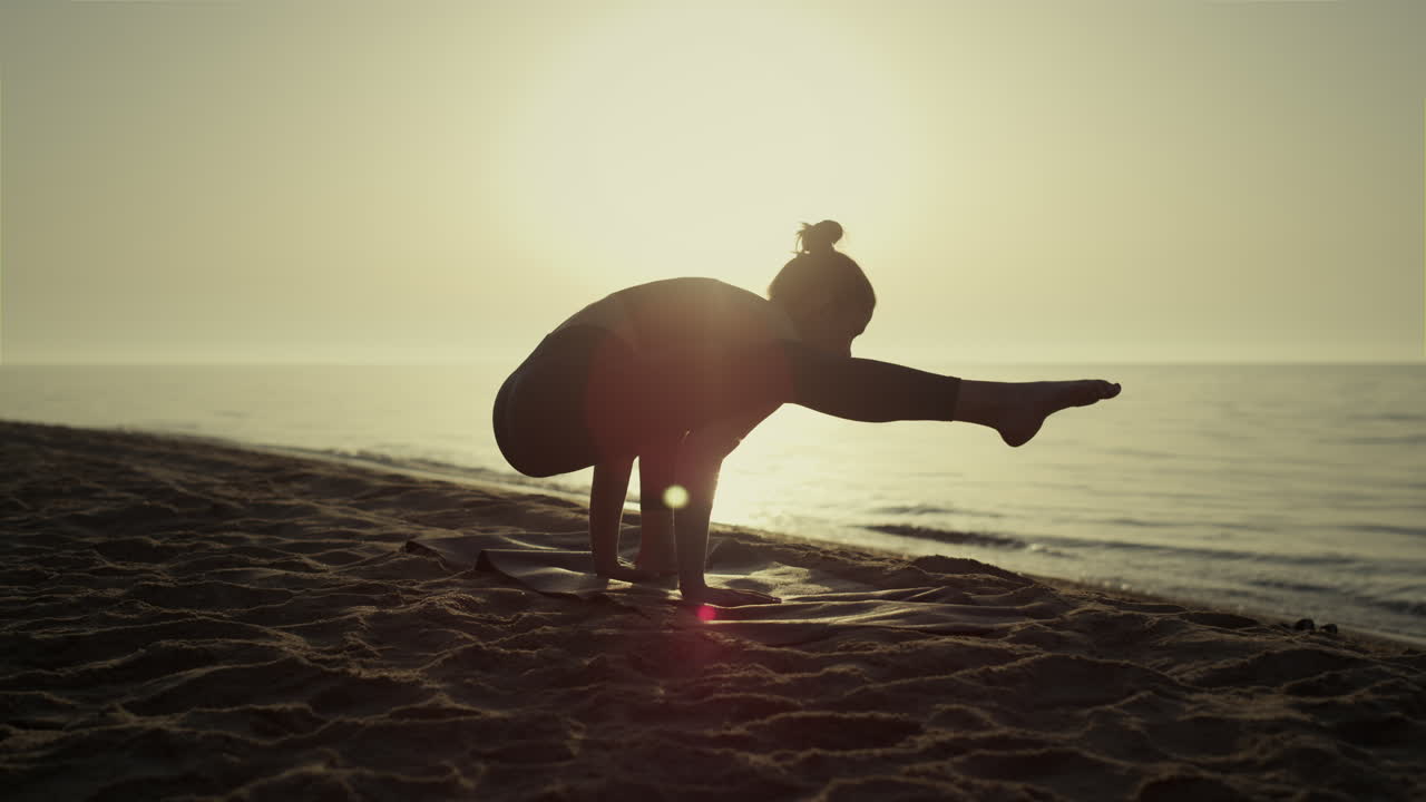 일몰에 불꽃 포즈를 수행하는 스포츠 소녀. 요가를 연습하는 여성.