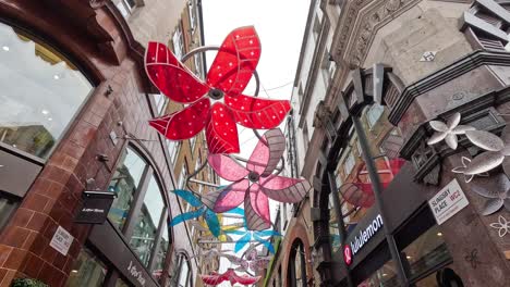 decorative flowers adorn a bustling shopping street