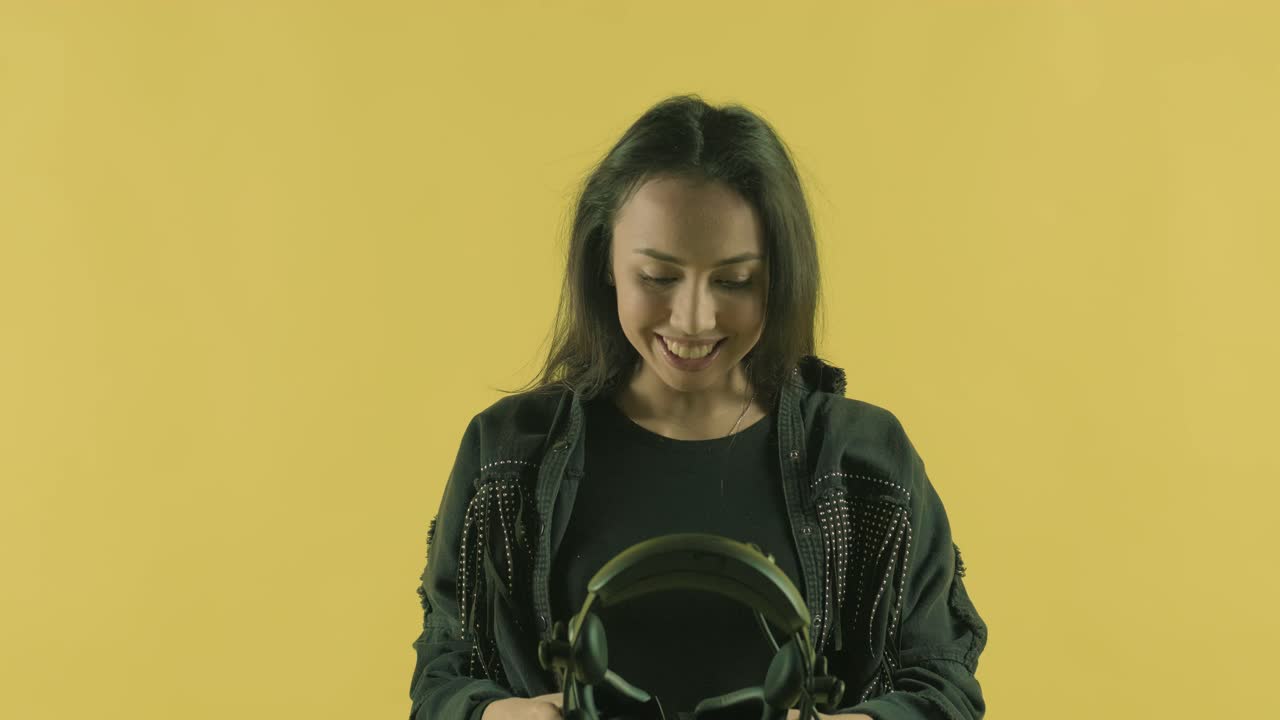 una mujer joven se apaga el auricular de realidad virtual, mira a su alrededor y se pregunta qué tan increíble es el mundo de realidad virtual. casco de realidad virtual en el fondo amarillo