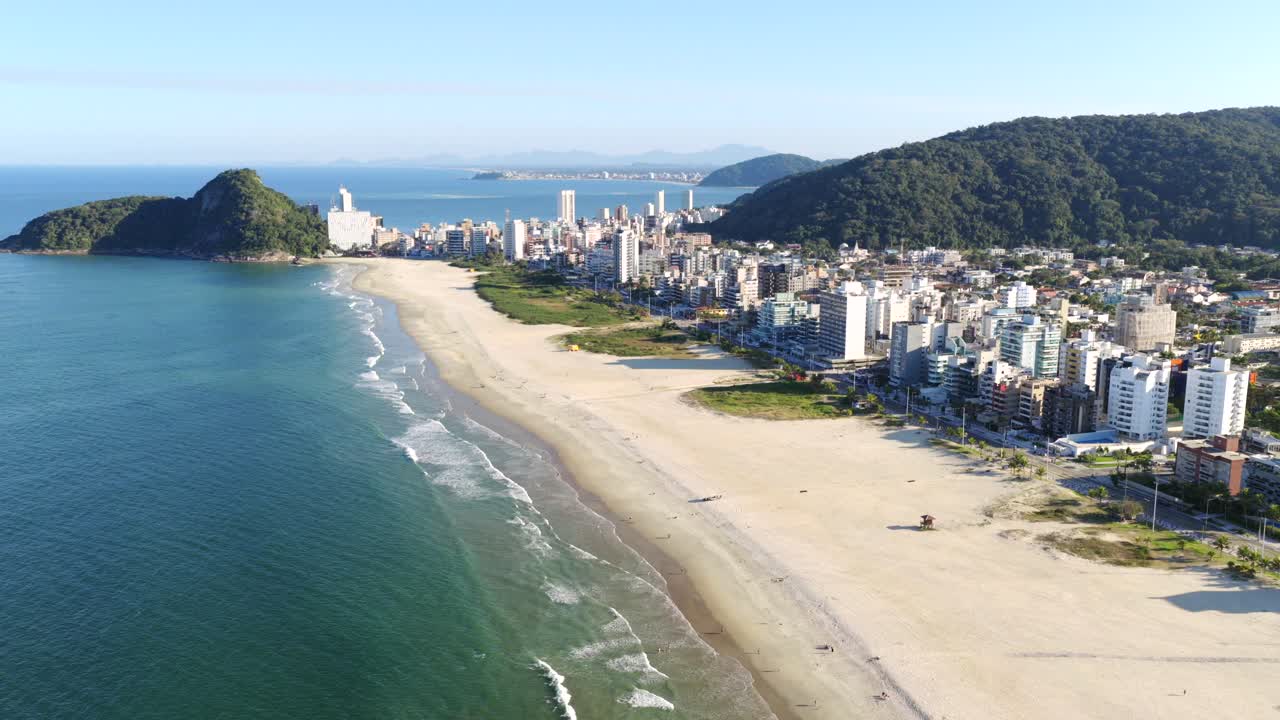 Backward aerial fly panorama from long sandy Caiobá beach with blue Atlantic Ocean beside coastal Matinhos municipality, Paraná, Brazil