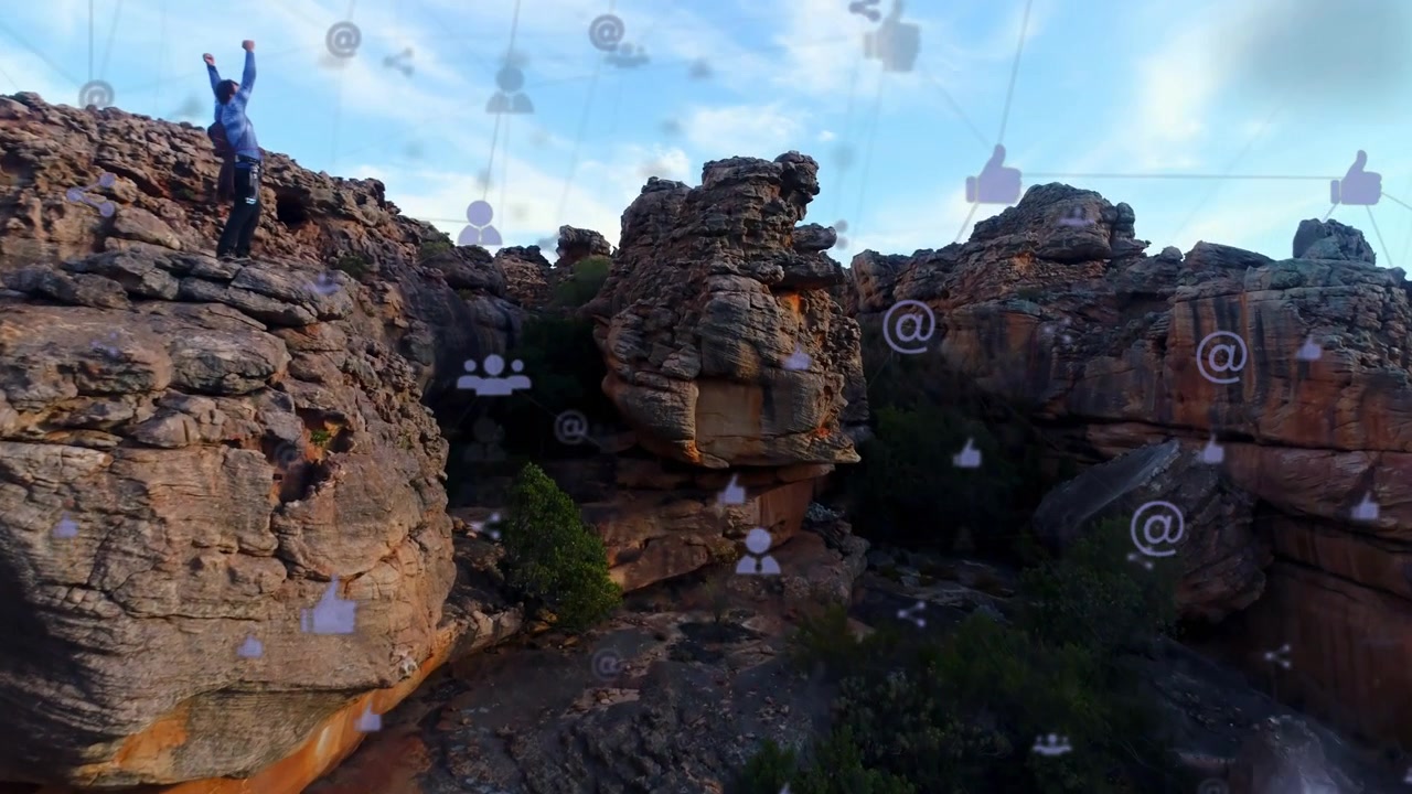 Male hiker celebrating by raising arms while camera gliding forward and layering social media icons