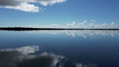 Gliding-smoothly-over-glassy-calm-water-in-Florida-with-the-Skyway-bridge-in-the-distance-on-a-sunny-day