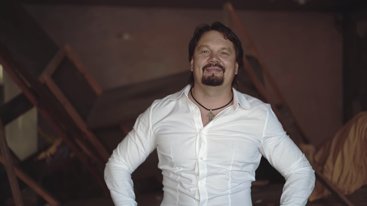 retrato de un joven brutal con barba que ríe y ajusta su cabello con las manos