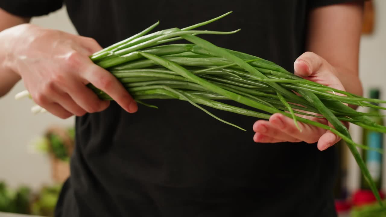 Person holding fresh green onions