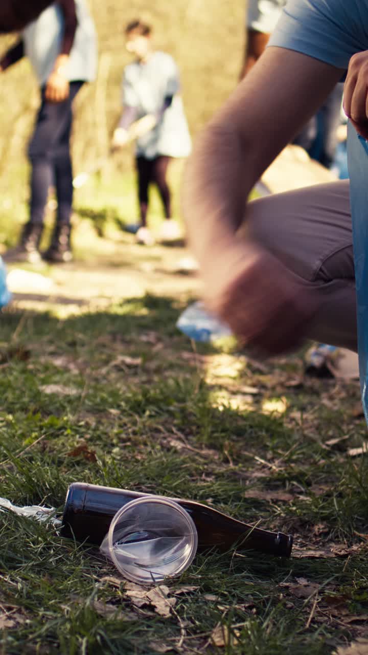 Volunteer Picking Up Trash from the Ground in a Park