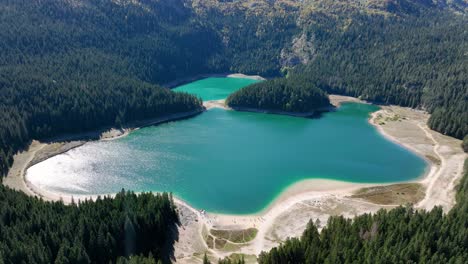 aerial view of a stunning mountain lake with turquoise water and lush forest