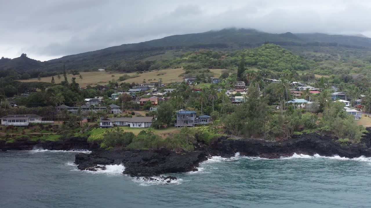 Low aerial dolly shot along the small Hawaiian village of Hana on the windward coast of Maui in Hawai'i