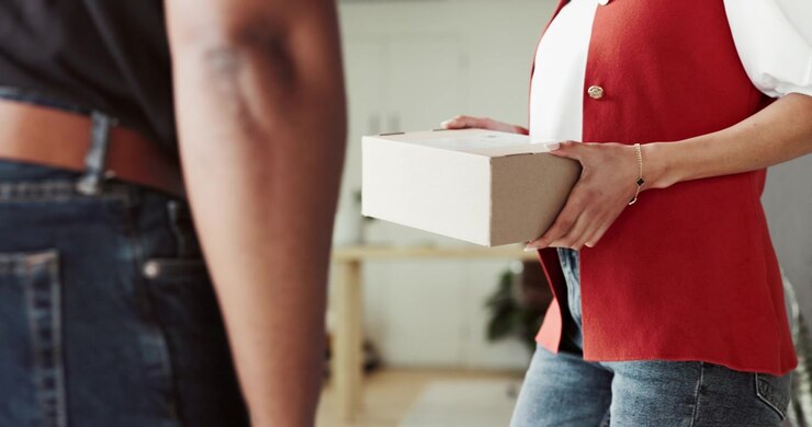 Delivery Person Handing a Package to a Woman at Home