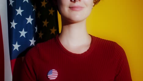 young woman with american flag and vote badge