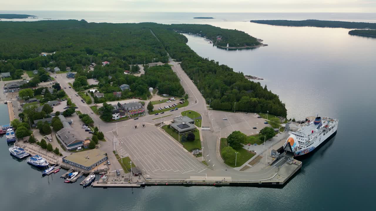 Aerial view of a large ferry docked in a busy harbor of a coastal town