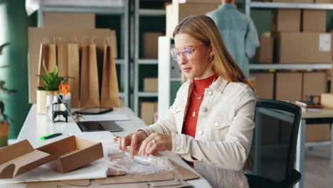 woman packing orders for shipping in a small business office