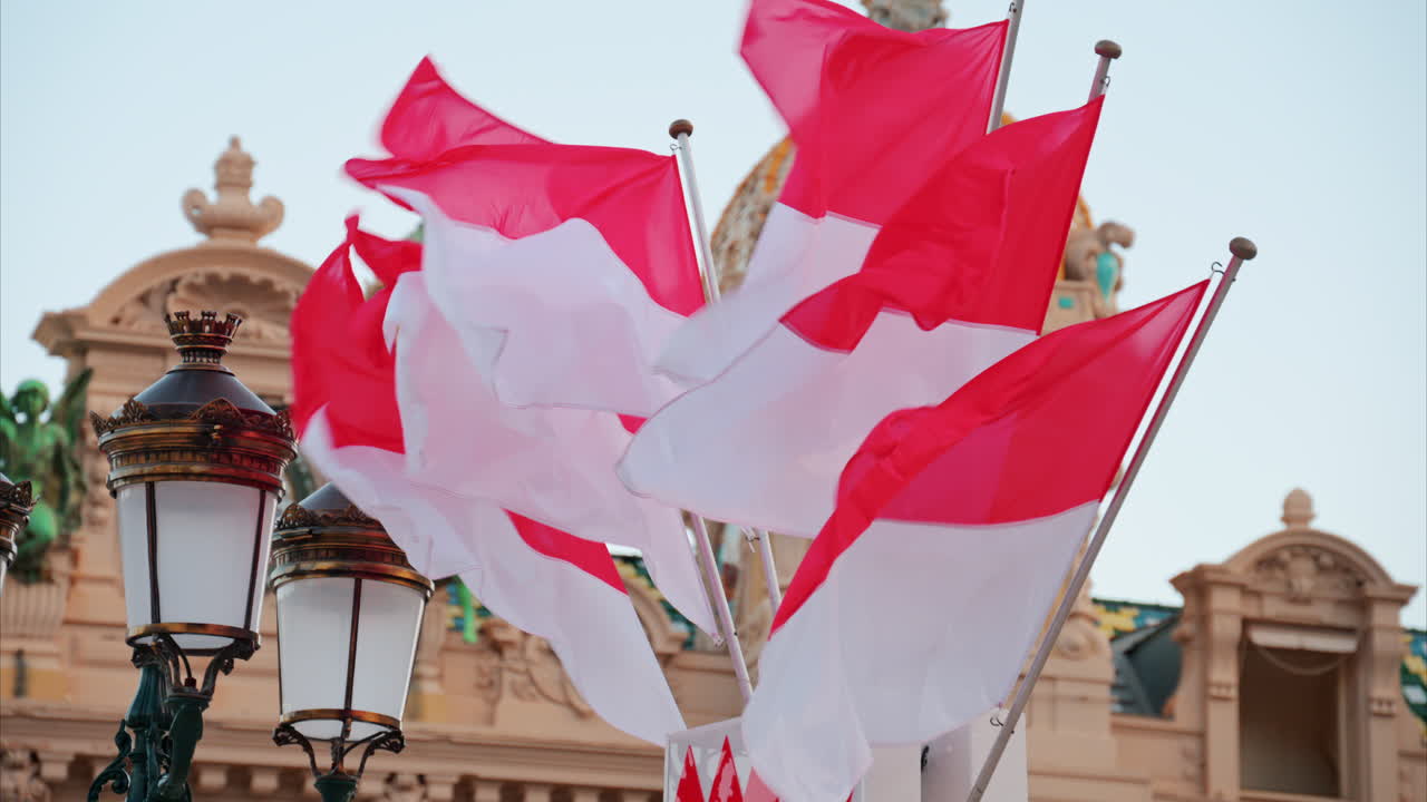 Monte Carlo, Monaco - October 24, 2024: The coat of arms of Monaco and multiple flags waving in front of the Monte Carlo Casino